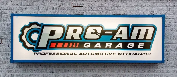 The Pro-AM Garage sign mounted on the shop's painted brick wall