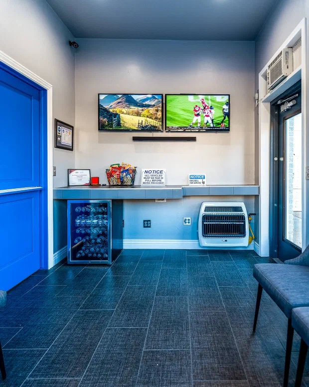 The Pro-AM Garage waiting room, with seating, a television and cold drinks